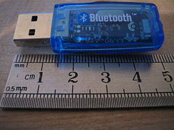 A typical Bluetooth USB dongle, shown here next to a metric ruler