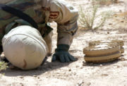 May 18, 2004: Staff Sgt. Kevin Jessen checks the underside of two anti-tank mines found in a village outside Ad Dujayl, Iraq in the Sunni Triangle.