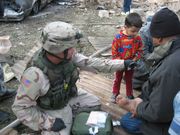 A US soldier-paramedic tends to some injuries after two car bombs exploded November 18, 2005 near a residential area in Baghdad.