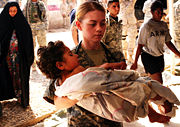 A soldier carries a wounded Iraqi child into the Charlie Medical Centre at Camp Ramadi, Iraq, March 20, 2007