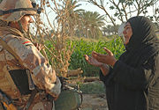 A woman pleads to an Iraqi army soldier from 2nd Company, 5th Brigade, 2nd Iraqi Army Division to allow a suspected insurgent free during a raid near Tafaria, Iraq