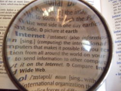A dictionary open at the word "Internet", viewed through a lens