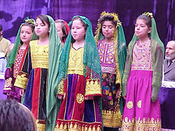 Girls in Kabul, wearing their traditional clothes, sing at a celebration of International Women's Day in 2002.