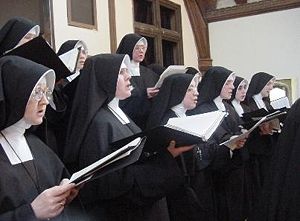 Nuns in traditional habit singing Gregorian chant.