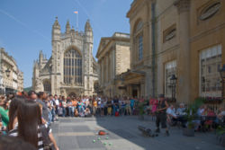 Bath swarms with tourists in the summer. This entertainer performs in front of Bath Abbey and to the right, the Roman Baths