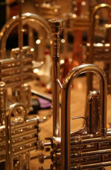Image of a trumpet, foreground, a piccolo trumpet behind, and a flugelhorn in background.
