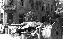 Poles erected barricades, such as this one on Napoleon Square, throughout Warsaw, making it difficult for German infantry and tanks to operate. In background: captured Hetzer tank destroyer.