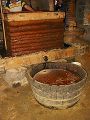 Most cider is made industrially nowadays, although traditional methods still survive. In this picture the layers of pomace are wrapped in canvas.