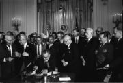 Lyndon B. Johnson signs the U.S. Civil Rights Act of 1964.