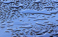 Small puddles of water on a smooth clean surface have perceptible thickness.