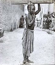 Slavery in Zanzibar. 'An Arab master's punishment for a slight offence. The log weighed 32 pounds, and the boy could only move by carrying it on his head.' Unknown photographer, c. 1890.
