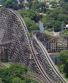 The cars of a roller coaster reach their maximum kinetic energy when at the bottom of their path. When they start rising, the kinetic energy begins to be converted to gravitational potential energy, but the total amount of energy in the system remains constant; assuming negligible friction and other energy conversion factors.
