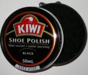 An open can of shoe polish with a side-mounted opening mechanism visible at the top of the photo