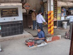 A boot polisher on a railway platform in Mumbai, India