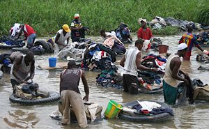 Poor inhabitants of the city laundering clothes in the river