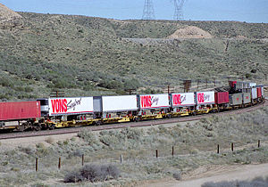 An intermodal train containing mechanically-cooled highway trailers in "piggyback" service passes through the Cajon Pass in February, 1995.