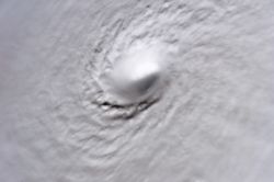 A picture of Hurricane Wilma's eye taken at 08:22 CDT (13:22 UTC) October 19, 2005, by the crew aboard the International Space Station. At the time, Wilma was the strongest Atlantic hurricane in history, with a minimum central pressure of only 882 mbar (26.06 inHg). Not only is this a classic example of a pinhole eye, but also of the stadium effect, where the eyewall slopes out and up.
