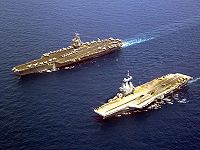 The USS Enterprise (left), the first nuclear-powered aircraft carrier in the world, sailing besides the Charles de Gaulle, the first nuclear-powered aircraft carrier in Europe. The French Navy gave assistance to U.S.-led efforts in Afghanistan.[2]