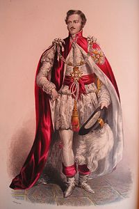 Knights Grand Cross wear their mantles over suits in modern times. During the nineteenth century, as depicted above, they wore them over imitations of seventeenth century dress.