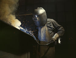 Arc welding with a welding helmet, gloves, and other protective clothing.