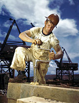 Carpenter using a crank-powered brace to drill a hole.