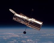 The Hubble Space Telescope orbiting above earth, containing optical instruments