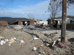 Severely damaged homes in piles of sand near the upper London Avenue Canal breach