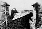 Nicéphore Niépce's earliest surviving photograph, c. 1826. This image required an eight-hour exposure, which resulted in sunlight being visible on both sides of the buildings.