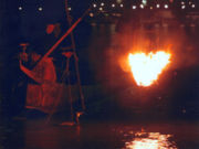 Japanese man displaying ancient cormorant night fishing technique.