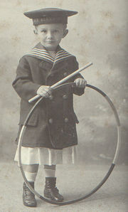A boy with a hoop.  Hoops have long been a popular toy across a variety of cultures.