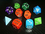 Typical role-playing dice, showing a variety of colors and styles. Note the older hand-inked green 12-sided die (showing an 11), manufactured before pre-inked dice were common. Many players collect or acquire a large number of mixed and unmatching dice.