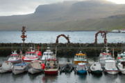The harbor at Fuglafjørður, Faroe Islands shows seven typical Faroe boats used for fishing.
