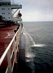 A cargo ship pumps ballast water over the side