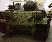Rear view of a T-34-85. In the centre is a circular transmission access hatch, flanked by exhaust pipes, MDSh smoke canisters on the hull rear, and extra fuel tanks on the hull sides.