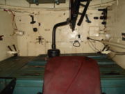 Interior of a T-34-85 tank viewed from the driver's hatch, showing the ammunition boxes on which the loader had to stand in the absence of a turret basket.  In the foreground is the driver's seat.