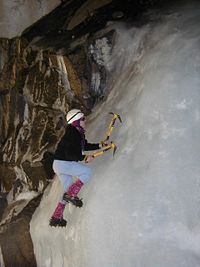 An ice climber using special equipment.