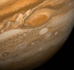 This dramatic view of Jupiter's Great Red Spot and its surroundings was obtained by Voyager 1 on February 25, 1979, when the spacecraft was 9.2 million km (5.7 million mi) from Jupiter. Cloud details as small as 160 km (100 mi) across can be seen here. The colorful, wavy cloud pattern to the left of the Red Spot is a region of extraordinarily complex and variable wave motion. To give a sense of Jupiter's scale, the white oval storm directly below the Great Red Spot is approximately the same diameter as Earth.