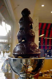 Chocolate made with enough cocoa butter flows gently over a chocolate fountain to serve dessert fondue.