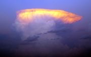 The setting sun illuminates the top of a classic anvil-shaped thunderstorm cloud in eastern Nebraska, United States.