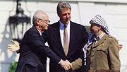 Yitzhak Rabin and Yasser Arafat shake hands, presided over by Bill Clinton, at the signing of the Oslo Accords, September 13, 1993