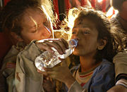 A young girl drinking bottled water.