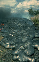 Toes of a pāhoehoe advance across a road in Kalapana on the east rift zone of Kīlauea Volcano in Hawaiʻi, United States.