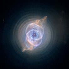 Image of NGC 6543 processed to reveal the concentric rings surrounding the inner core.  Also visible are the linear structures, possibly caused by precessing jets from a binary central star system.
