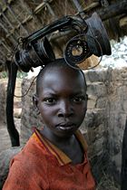 A boy playing with a burnt lamp in the city of Birao, Central African Republic. The town was almost completely burnt down in March 2007 during fighting between rebels and government troops.