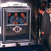 The crew of Apollo 11 in quarantine after returning to Earth, visited by Richard Nixon