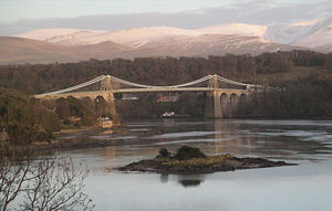 The Menai Strait in 2004 crossed by a suspension bridge, with Eryri in the background. Control of the Menai and access to Ynys Môn was crucial for medieval Gwynedd.