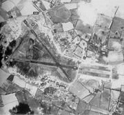 An aerial view of RAF Exeter airfield on 20 May 1944, showing the triangular layout of the runways allowing aircraft to always take off and land into the wind