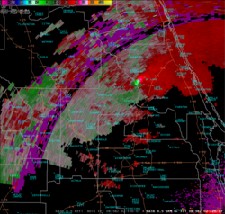 A Doppler radar image indicating the likely presence of a tornado over DeLand, Florida.  Green colors indicate areas where the precipitation is moving towards the radar dish, while red areas are moving away.  In this case the radar is in the bottom right corner of the image.  Strong mesocyclones show up as adjacent areas of bright green and bright red, and usually indicate an imminent or occurring tornado. When these bright colors are one against the other on a radar display when in association with rotation, it is called a Tornado vortex signature.
