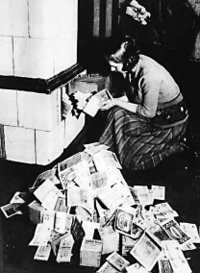 Inflation 1923–24: a woman feeds her tiled stove with money. At the time, burning money was less expensive than buying firewood.