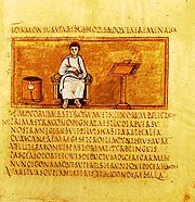 Folio 14 recto of the 5th century Vergilius Romanus contains an author portrait of Virgil. Note the bookcase (capsa), reading stand and the text written without word spacing in rustic capitals.